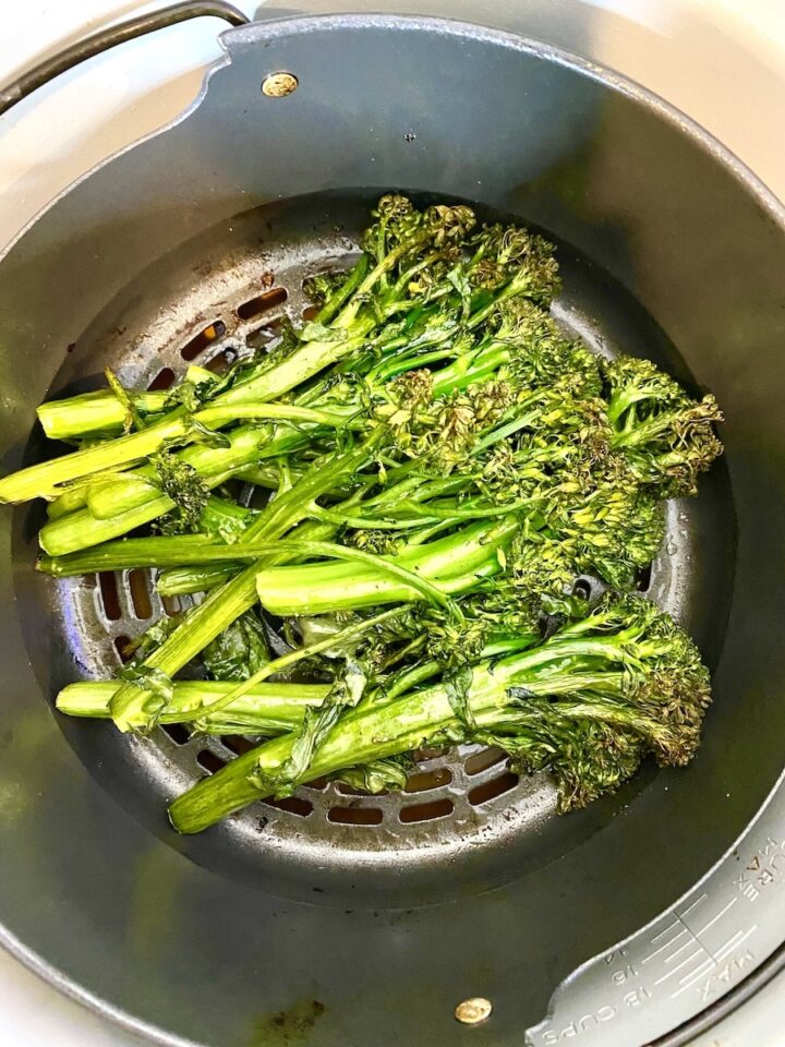 cooked broccolini in a Ninja Foodi Air Fryer basket