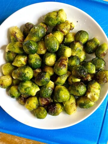 air fried frozen brussel sprouts served in a white bowl over a blue place mat